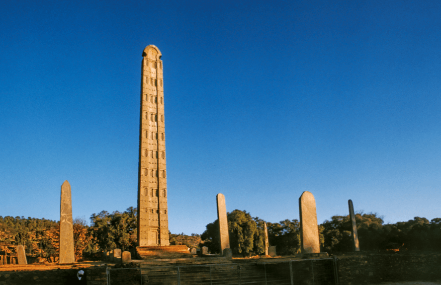 Carved granite stelae standing in the stelae field at Axum, Ethiopia, against an open sky
