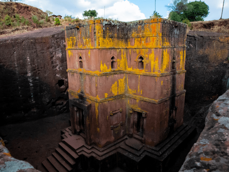 Bete Giyorgis at Lalibela seen from the rim, the cross-shaped roof and the rectangular pit cut down around it, with steps leading to the entrance