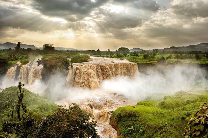 The Blue Nile Falls in full flow with sunlight breaking through cloud