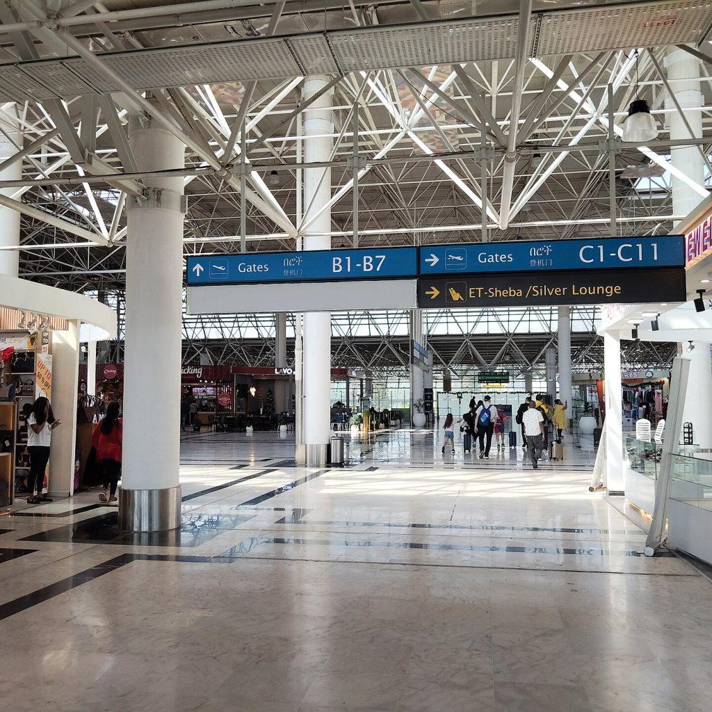 Overhead direction signs inside Bole airport pointing left to Gates B1 to B7 and right to Gates B8 and beyond