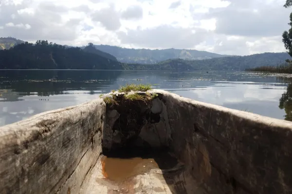 Boat on Wonchi crater lake surrounded by green hills